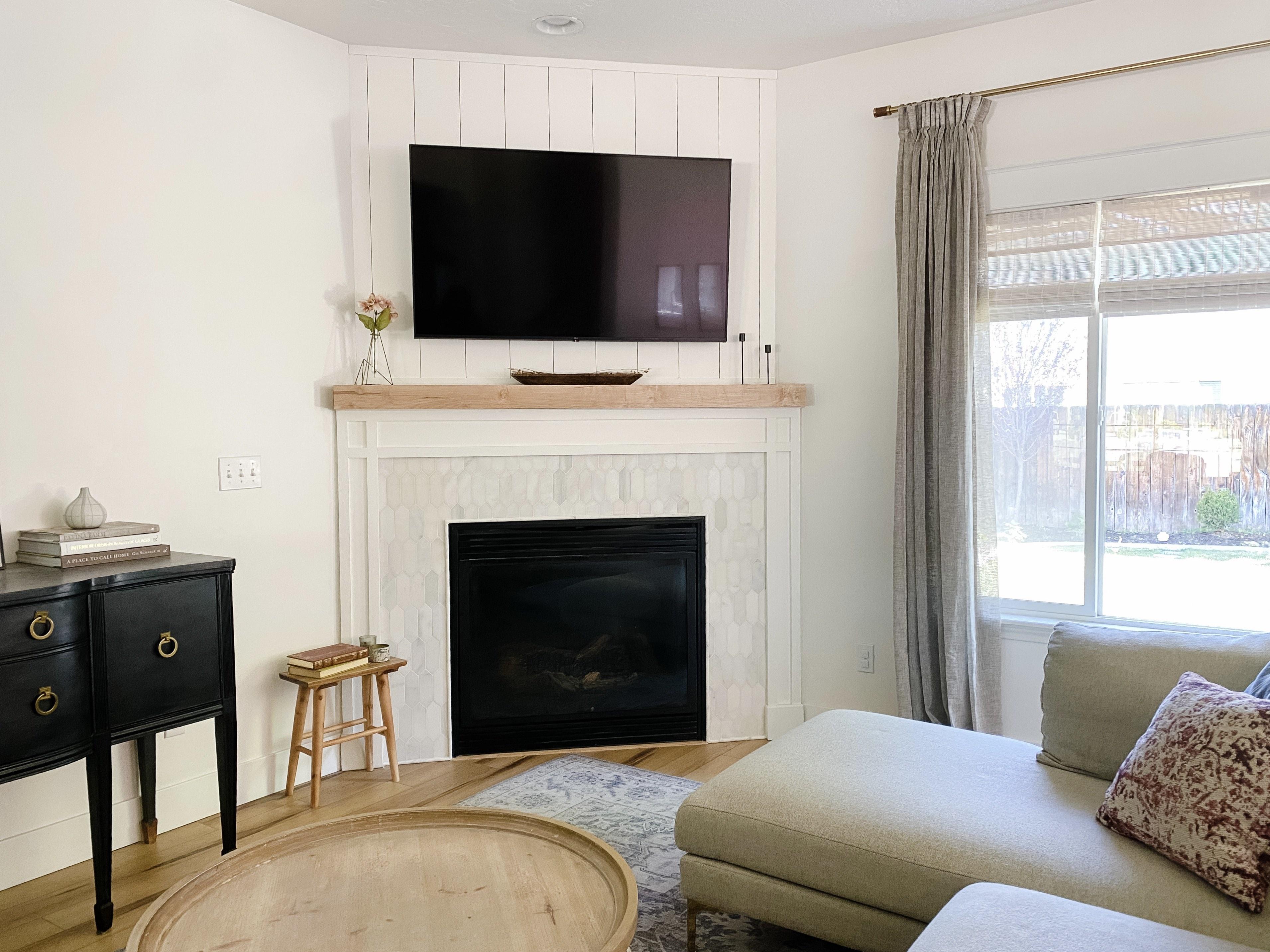 Corner fireplace makeover - painted white craftsman trim, wood mantle and marble picket tile surround.