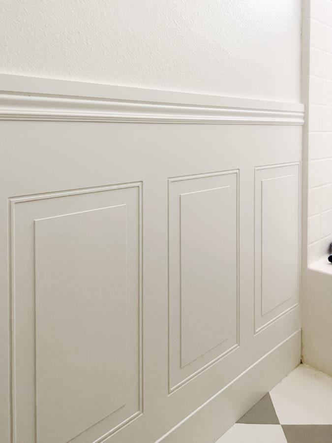 White wainscoting against a white wall bathroom